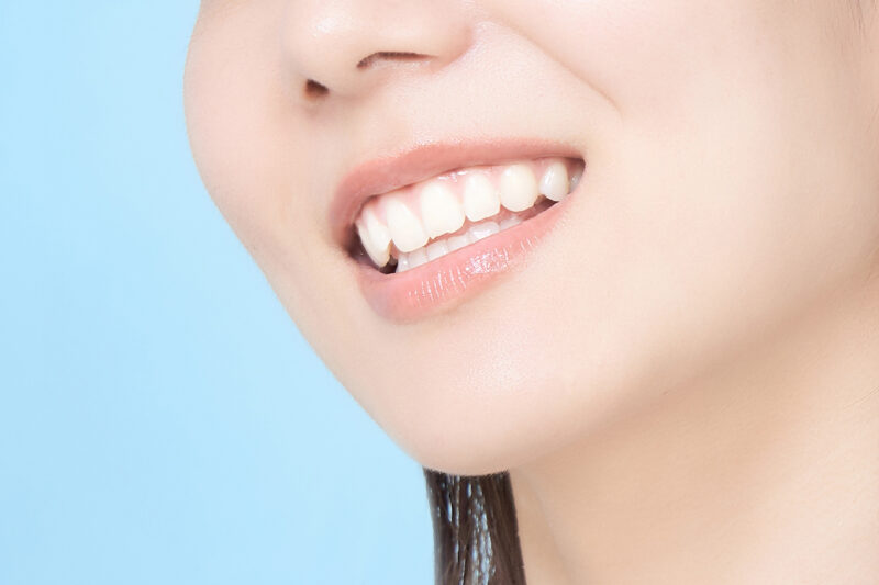 背景青白い歯を見せる女性