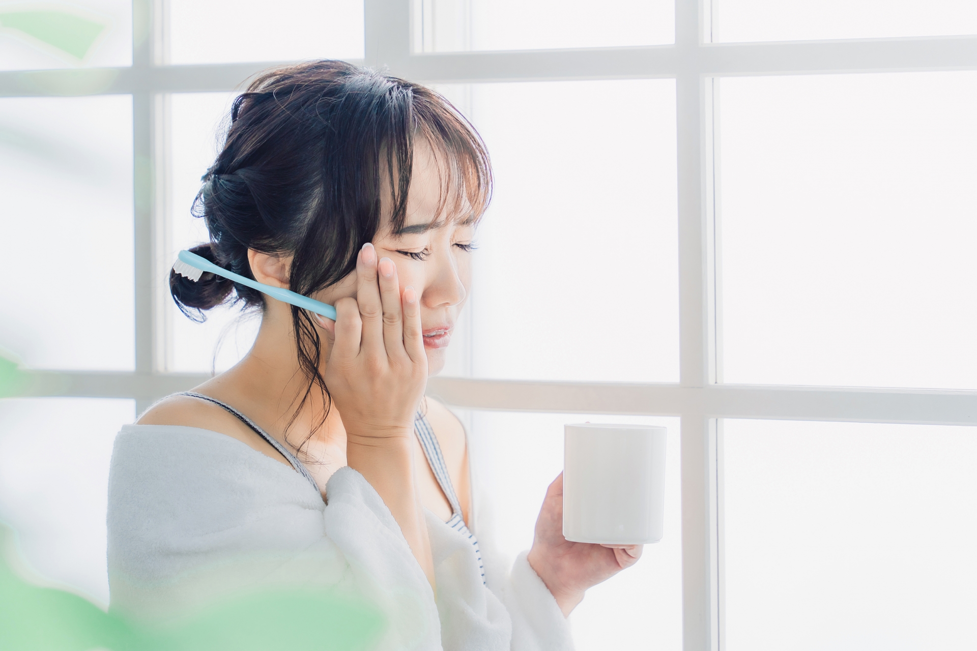 頬を押さえる女性