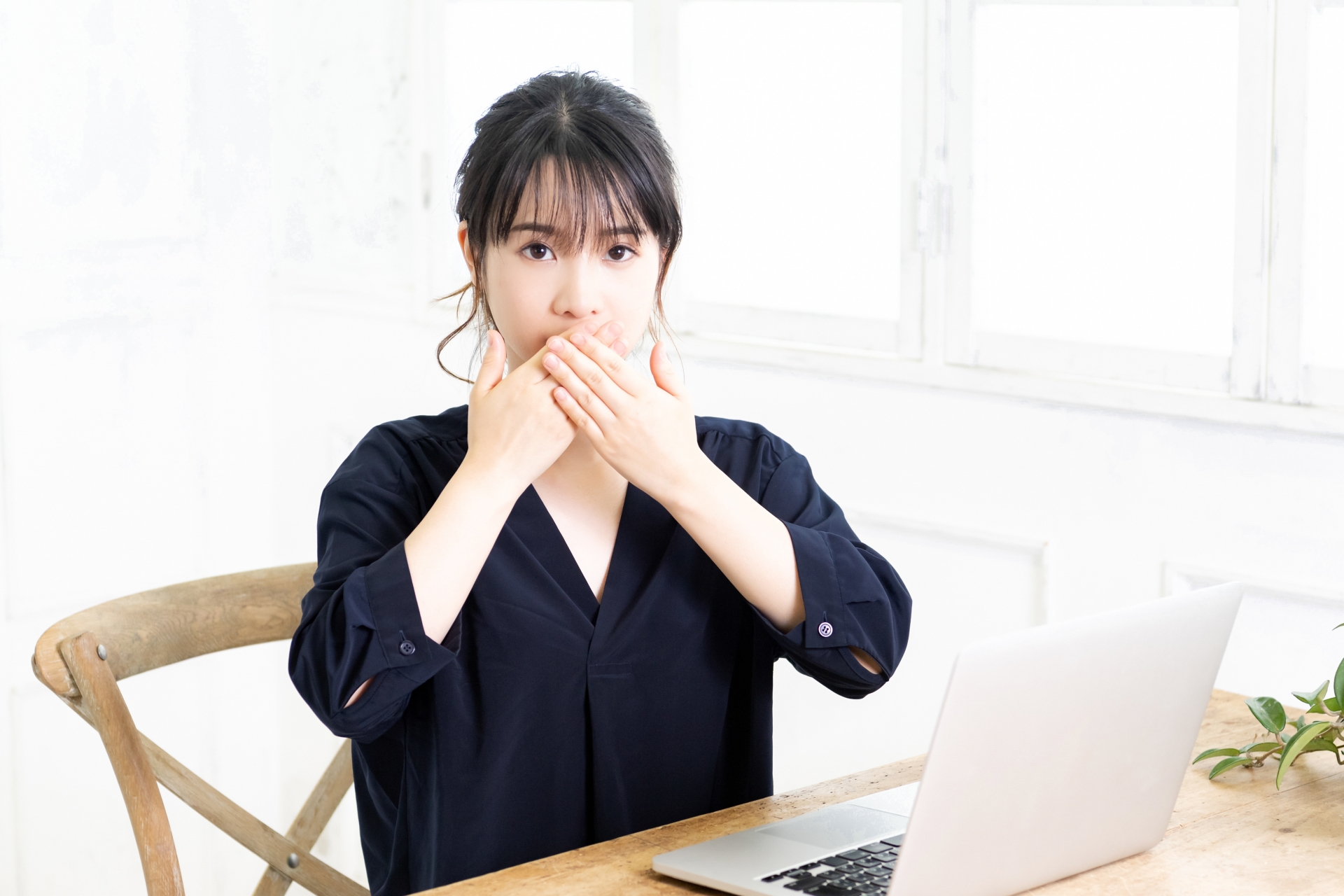 口を隠す若い女性