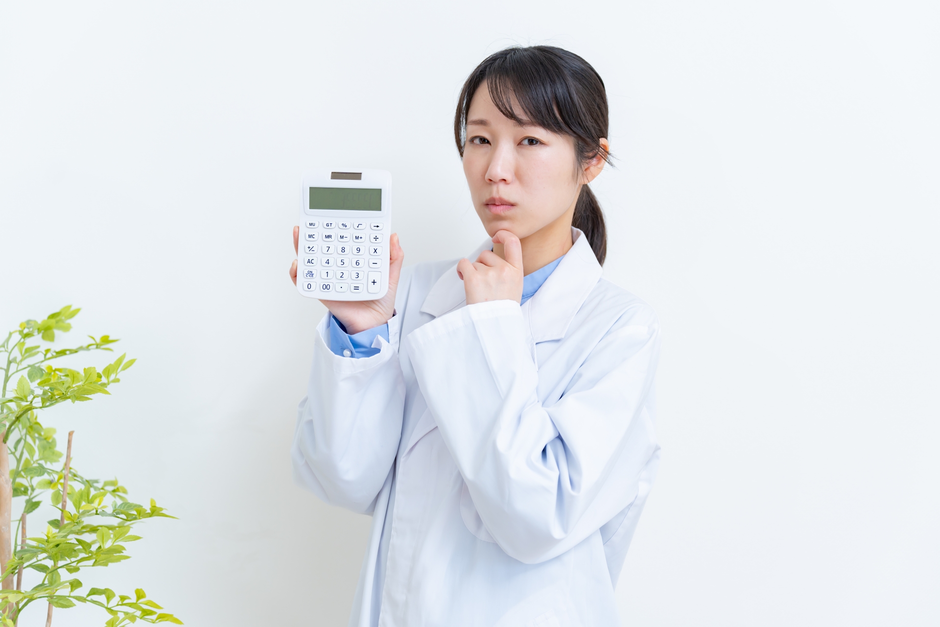 電卓を持ち悩む医師