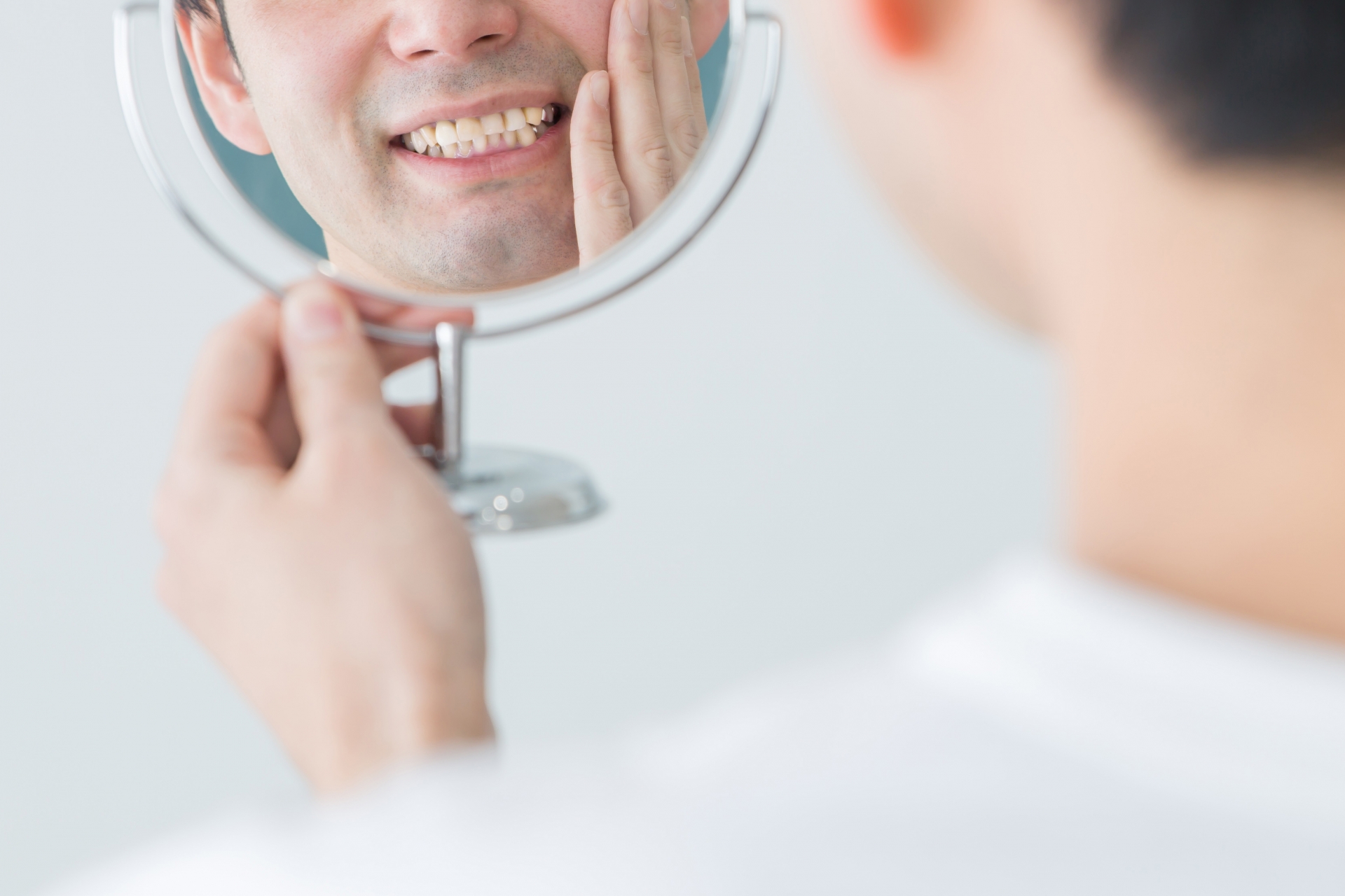 鏡を見て歯を確認している人