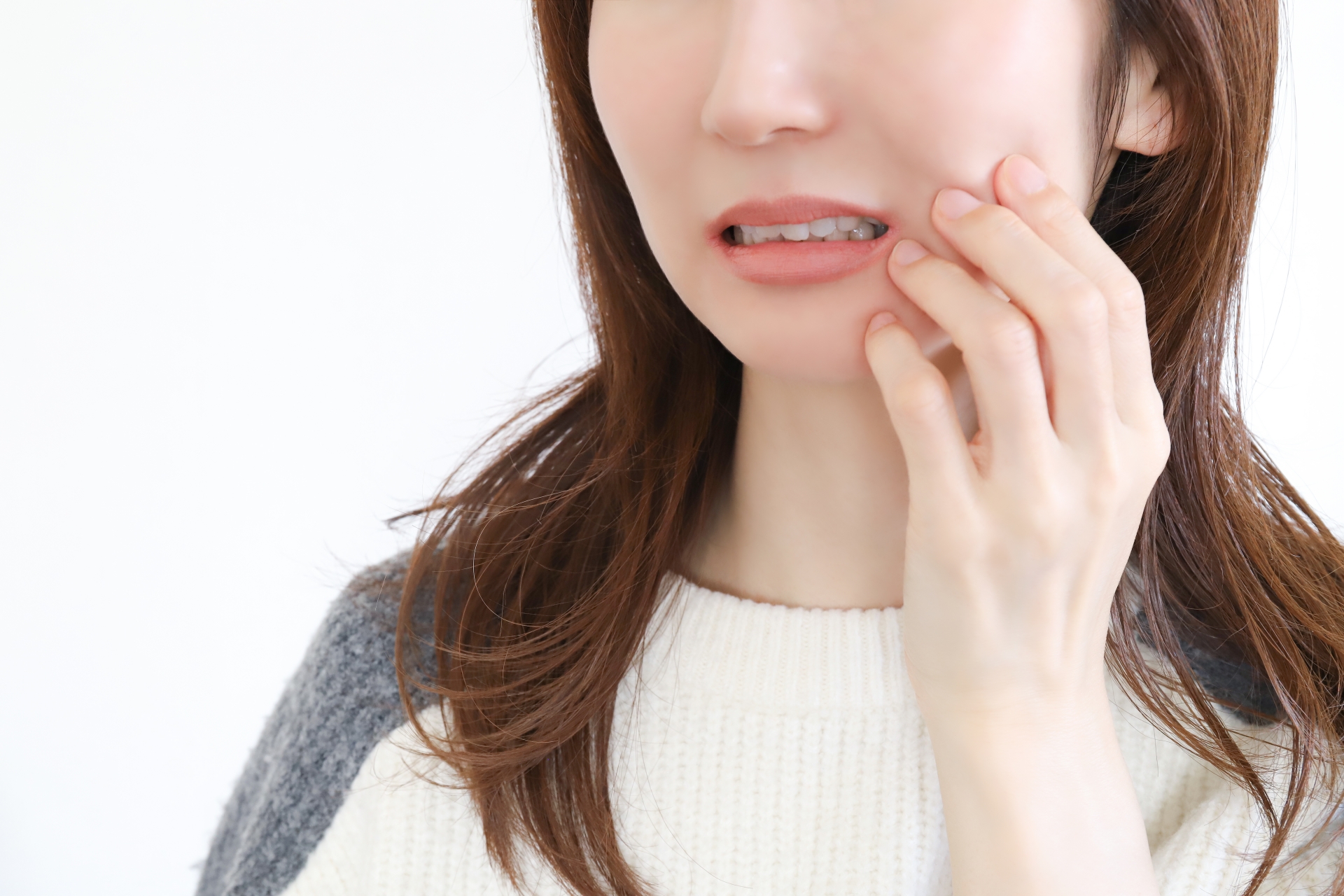 ほっぺたを押さえる女性
